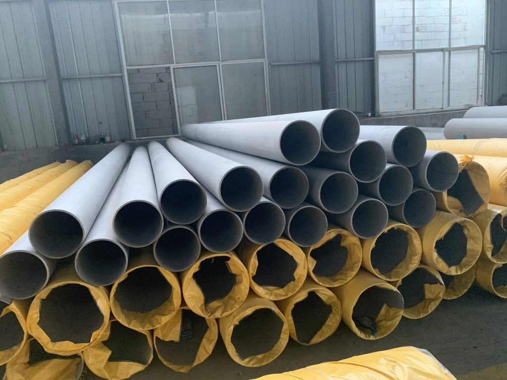 Stainless Steel Pipe Usage in Petrochemical Plants: Key Insights-1-Sunrise New Material A pile of large wha'cite pipes with yellow protective covers stacked in a warehouse